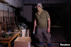 在伊久姆镇，一名乌克兰军人站在他说曾被俄军用作酷刑室的警察局的一间屋子里。(2022年9月18日)