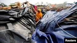 FILE - A young Rohingya refugee stands in her house which has been destroyed by Cyclone Mora at Balukhali Refugee Camp in Cox’s Bazar, Bangladesh, May 31, 2017.