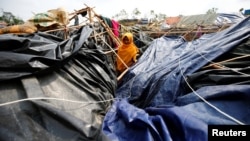 A young Rohingya refugee stands in her house which has been destroyed by Cyclone Mora at Balukhali Refugee Camp in Cox’s Bazar, Bangladesh, May 31, 2017.