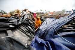FILE - A young Rohingya refugee stands in her house which has been destroyed by Cyclone Mora at Balukhali Refugee Camp in Cox’s Bazar, Bangladesh.