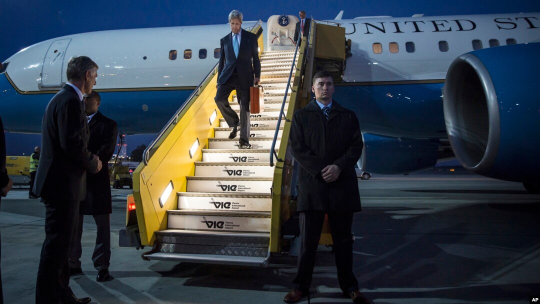 U.S. Secretary of State John Kerry walks down the stairs in the twilight after landing in Vienna, Oct. 22, 2015. 