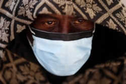 A man wears a protective mask while waiting for a bus in Detroit, Michigan, U.S., on April 8, 2020.