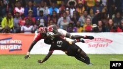 Le centre des Cranes de l’Ouganda, Michael Okorach (en bas), aux prises avec l’attaquant kenyan Oliver Mang'eni lors du match des qualifications pour la Coupe du Monde de Rugby de l'Union Japonaise-2019 - entre le Kenya et l'Ouganda, Nairobi, 7 juillet 20