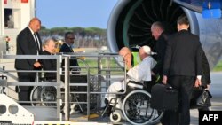 Pope Francis seated on a wheelchair boards his plane heading to Luxembourg on September 26, 2024 at Rome's Fiumicino airport.