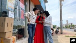 Women from the the Hui Muslim ethnic minority from a nearby neighborhood gather outside a shop near an OFILM factory in Nanchang in eastern China's Jiangxi province, June 5, 2019.