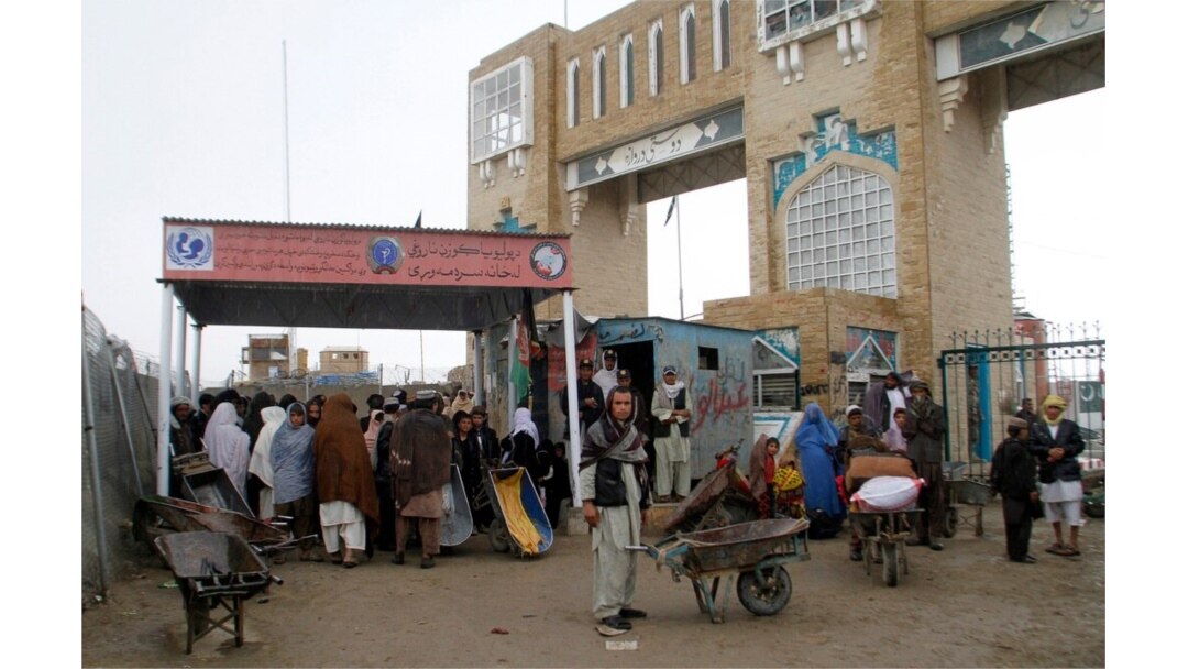 FILE - Families wait to cross the Afghanistan-Pakistan border point in Spin Boldak, Kandahar province, Afghanistan, March 7, 2017.