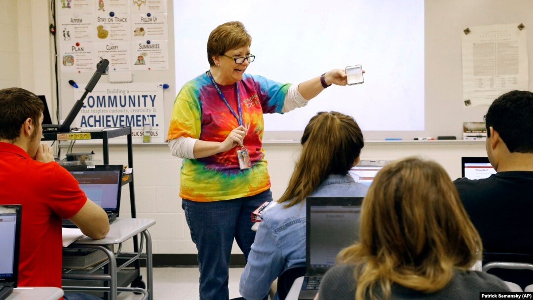 FILE - Teacher Carol Mowen shows a cell phone app while preparing her students to participate in the oral history project StoryCorps at Washington County Technical High School in Hagerstown, Md. (AP Photo/Patrick Semansky)