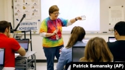 FILE - Teacher Carol Mowen shows a cell phone app while preparing her students to participate in the oral history project StoryCorps at Washington County Technical High School in Hagerstown, Md. (AP Photo/Patrick Semansky)