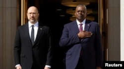 Menteri Pertahanan AS Lloyd Austin (kanan) menyambut kedatangan Perdana Menteri Ukraina Denys Shmyhal di Pentagon, Arlington, Virginia, pada 12 April 2023. (Foto: Reuters/Jonathan Ernst)