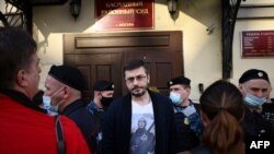 A man wearing a T-shirt with an image of Russian President Vladimir Putin leaves Basmanny district court during a hearing on pre-trial measures against journalists of student news site DOXA charged with inciting minors to protest, Moscow, Apr. 14, 2021.