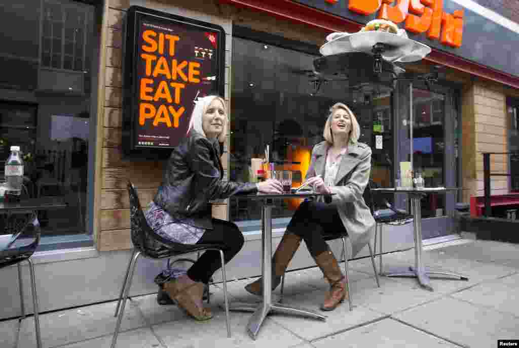 A flying sushi service tray known as the "itray", created using miniature remote-controlled helicopter rotor blades, is demonstrated at a "Yo! Sushi" restaurant in London, June 10, 2013.