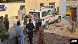 Hombres afganos junto a una ambulancia después de un ataque con bomba en una mezquita en Kunduz el 8 de octubre de 2021.