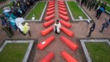 An Orthodox priest conducts a burial ceremony of 228 Soviet soldiers killed during World War II, in a memorial cemetery at Nevsky Pyatachok near Kirovsk, Russia.