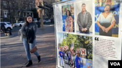 Una mujer camina y observa una de las piezas de una exposición itinerante de fotografías que se expone estos días en una plaza del barrio de Mount Pleasant en Washington sobre vidas de personas con TPS. (Foto: Tomás Guevara, VOA)