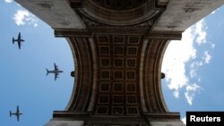 Military aircrafts fly over the Arc de Triomphe during a rehearsal for the Bastille Day celebrations in Paris, France.
