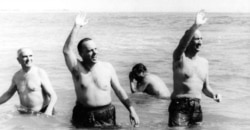 FILE - U.S. Ambassador Angier Biddle Duke, right, and Manuel Fraga, Spanish minister of information and tourism, wave from chilly waters off Palomares Beach, Spain, March 8, 1966.