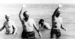 FILE - U.S. Ambassador Angier Biddle Duke, right, and Manuel Fraga, Spanish minister of information and tourism, wave from chilly waters off Palomares Beach, Spain, March 8, 1966.