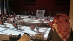 FILE - Saudi journalists watch a screen showing the meeting of the 41st Gulf Cooperation Council taking place in Al Ula, Saudi Arabia, Jan. 5, 2021.