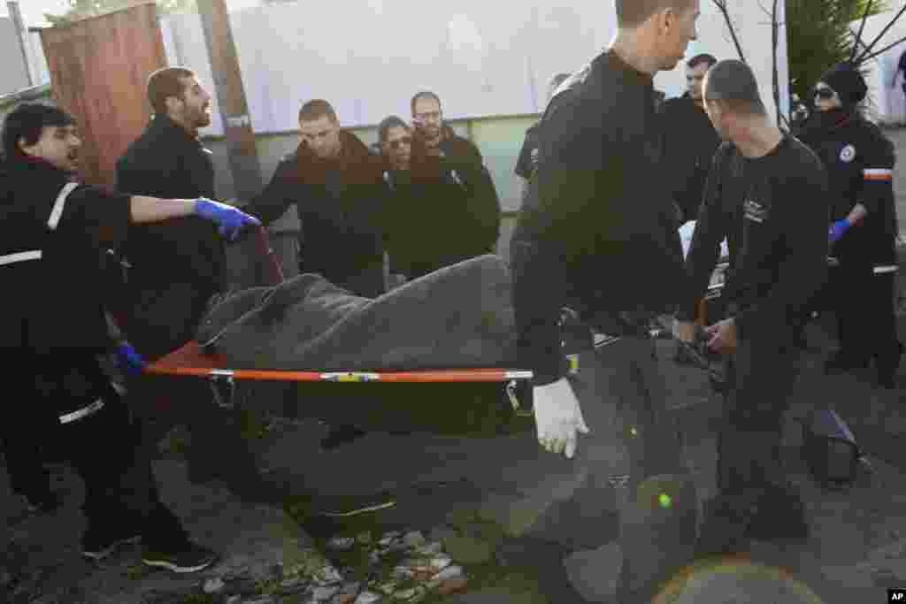 Israeli police officers and medics carry a Palestinian man suspected of stabbing people who were on or near a city bus in Tel Aviv, Jan. 21, 2015.