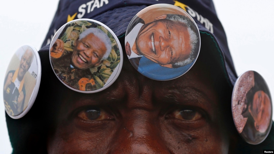 Mũ, bích chương và nút có hình ông Mandela được bán tại tất cả các địa điểm tưởng niệm.