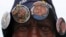 A street vendor offers buttons with pictures of Nelson Mandela outside the house where the anti-apartheid icon once lived in the township of Soweto, Dec. 9, 2013.