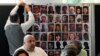 Relatives of the deceased and people directly affected by the Grenfell Tower fire, sit in front of a photo montage of the those who died, as they react to the final report into the fire being released in London, Sept. 4, 2024. 