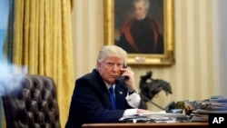 FILE - President Donald Trump speaks on the phone with Prime Minister of Australia Malcolm Turnbull in the Oval Office of the White House, Jan. 28, 2017.