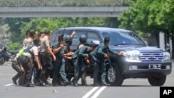 Polisi berlindung di balik sebuah kendaraan saat baku tembak dengan pelaku serangan teror di kawasan Sarinah-Thamrin Jakarta, 14 Januari lalu (foto: dok).