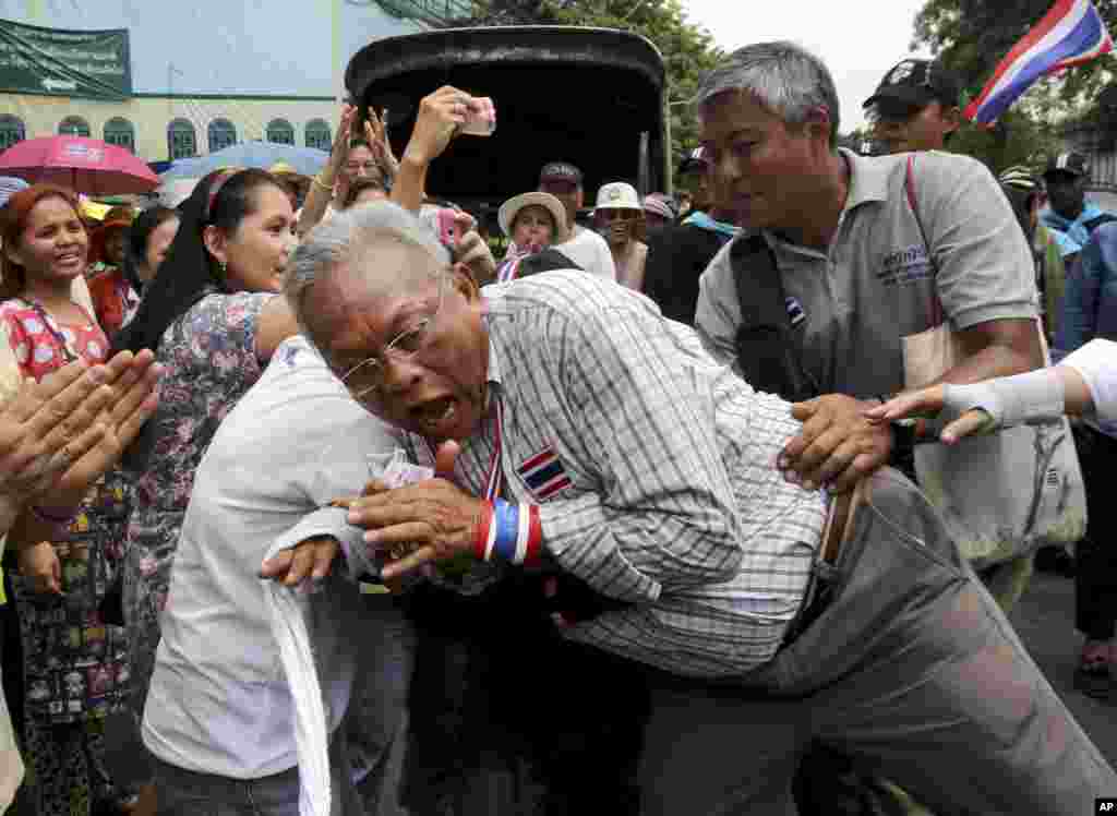 Leader of anti-government protesters Suthep Thaugsuban reacts as he is hugged by a supporter during a march in Bangkok, Thailand.