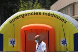 A health worker wearing a protective mask walks past a field hospital outside Arnau de Vilanova hospital, after a judge barred Catalan authorities from enforcing a stricter lockdown to residents in the city of Lleida, July 13, 2020.