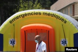 A health worker wearing a protective mask walks past a field hospital outside Arnau de Vilanova hospital, after a judge barred Catalan authorities from enforcing a stricter lockdown to residents in the city of Lleida, July 13, 2020.