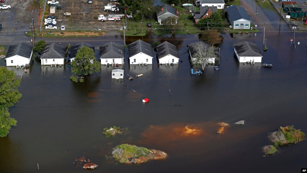 FILE - Floodwaters from Hurricane Florence surround homes in Dillon, S.C., Sept. 17, 2018. Scientists say climate change likely boosted rainfall totals for both Florence and 2017's Harvey. 