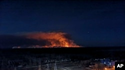 In this photo taken from the roof of Ukraine's Chernobyl nuclear power plant April 10, 2020, a forest fire is seen burning near the plant inside the exclusion zone.