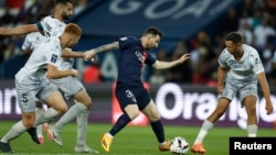 Messi, con camiseta azul al centro del París St. Germain, driblea el balón entre atacantes del Clermont de la liga francesa, el 3 de junio de 2023.