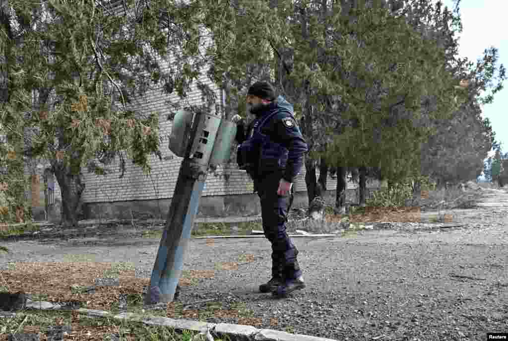 A police officer inspects the remains of a Russian rocket shell in the frontline town of Orikhiv in Zaporizhzhia region, Ukraine, Jan. 8, 2025.