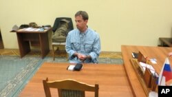 En esta foto proporcionada por el Servicio de Seguridad Federal de Rusia, el estadounidense Ryan Fogle (derecha), se encuentra en las oficinas del servicio de seguridad rusa, luego de ser detenido en Moscú.