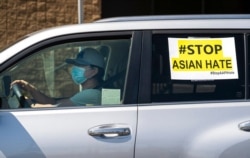 FILE - Members of the Korean American Federation of Los Angeles drive with signs reading "#Stop Asian Hate," in a caravan around Koreatown, March 19, 2021.
