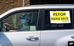FILE - Members of the Korean American Federation of Los Angeles drive with signs reading '#Stop Asian Hate,' in a caravan around Koreatown, March 19, 2021.