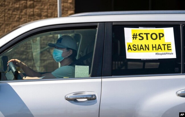 FILE - Members of the Korean American Federation of Los Angeles drive with signs reading '#Stop Asian Hate,' in a caravan around Koreatown, March 19, 2021.