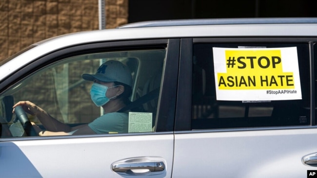 FILE - Members of the Korean American Federation of Los Angeles drive with signs reading "#Stop Asian Hate," in a caravan around Koreatown, March 19, 2021. (AP Photo/Damian Dovarganes, File)