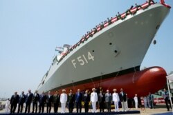 FILE - Turkey's President Recep Tayyip Erdogan, bottom center, accompanied by officials pose for photographs during the launch of a new Turkish Navy ship, in Tuzla, outside Istanbul, July 3, 2017.