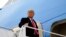 FILE - President Donald Trump gestures as he boards Air Force One upon arrival at Valley International Airport, in Harlingen, Texas, Jan. 12, 2021.