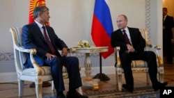 Russian President Vladimir Putin (R) and Kyrgyz President Almazbek Atambayev speak during their meeting in the Konstantin Palace outside St. Petersburg, Russia, March 16, 2015. 