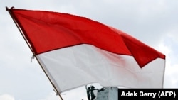 Seorang pengunjuk rasa mengibarkan bendera saat demonstrasi menentang dugaan konspirasi, 19 November 2009. (Foto: AFP/Adek Berry)