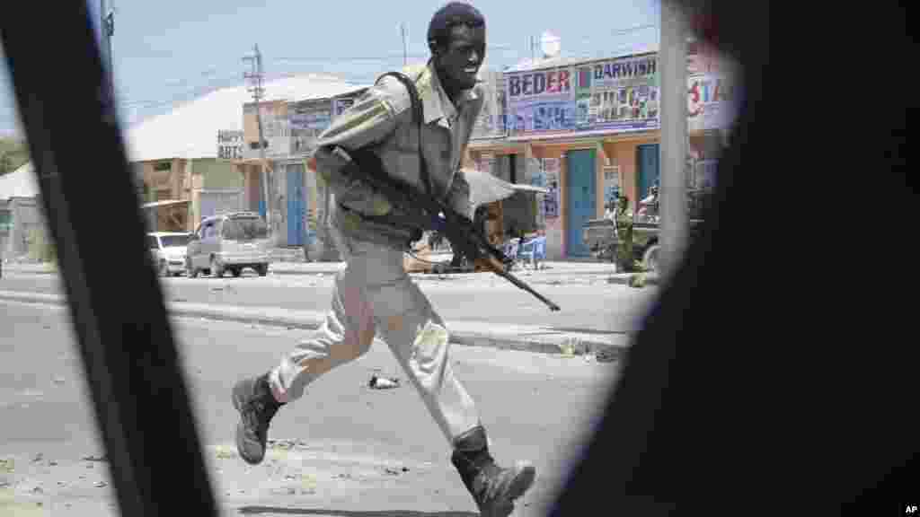 Mwanaje3shi wa Ki-Somali akikimbia wakati wa mapigano ya bunduki kufuatia mlipuko wa bomu.