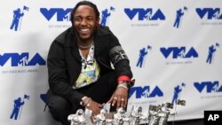 Kendrick Lamar poses in the press room with the awards for best hip hop video, best direction, best cinematography, best art direction, best visual effects, and video of the year for "HUMBLE." at the MTV Video Music Awards, Aug. 27, 2017.