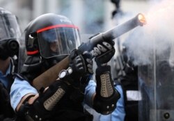 A police officer fires tear gas during a demonstration against a proposed extradition bill in Hong Kong, June 12, 2019.