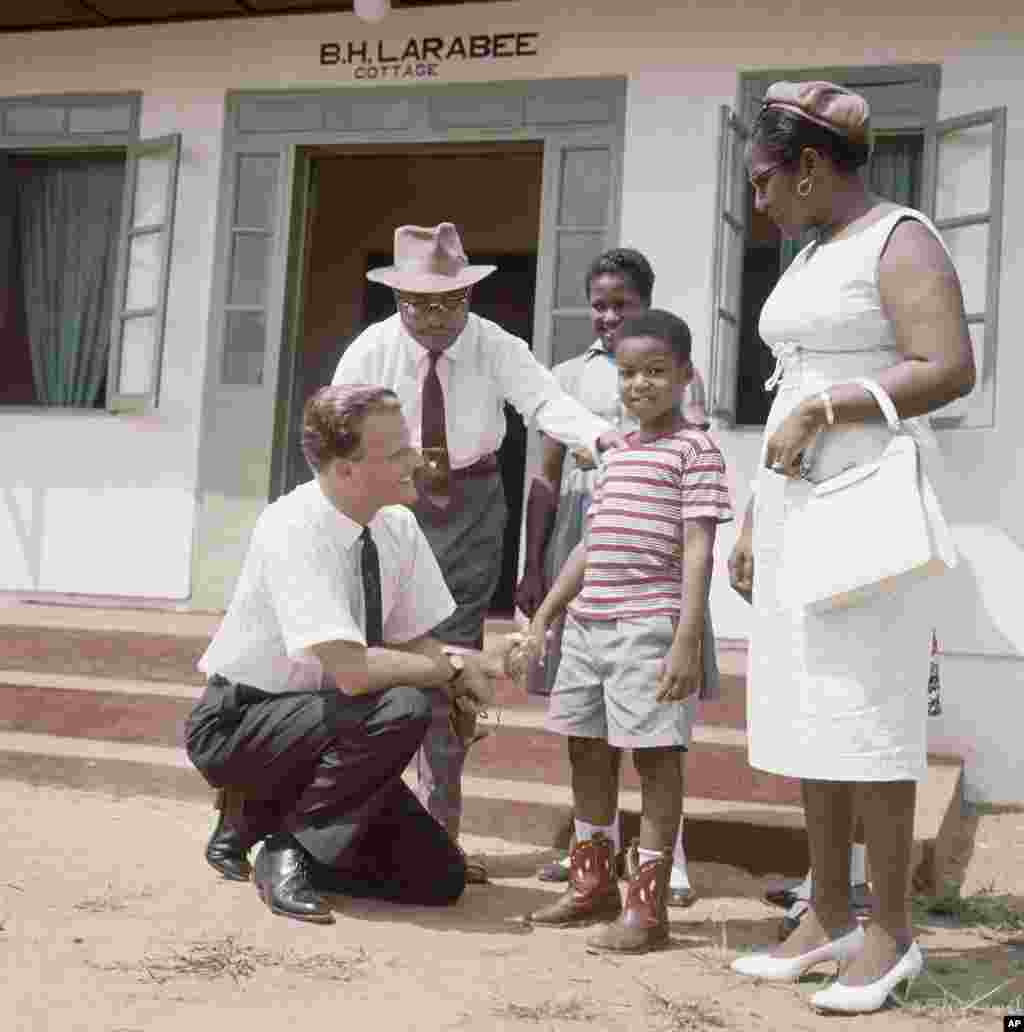 Billy Graham, évangéliste américain, parle avec des enfants du village de Virginia, à 30 kilomètres de Monrovia en 1960.