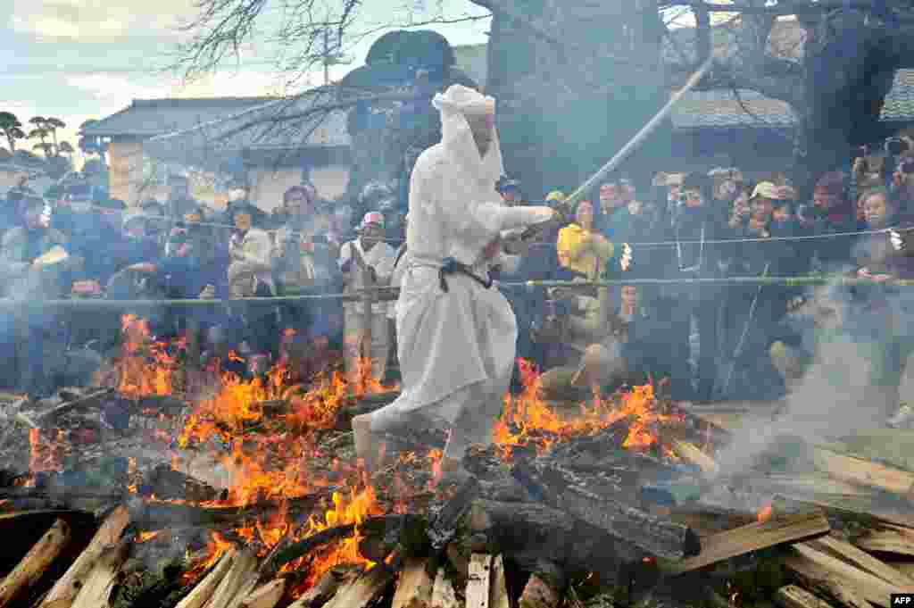 A Shinto priest walks across embers during a fire walking ceremony to pray for a safe and good healthy life at Kabasan Saenazumi Jinja shrine in Sakuragawa City, Ibaraki Prefecture, Japan.