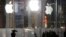 FILE - Pedestrians pass the Apple store location on Fifth Avenue in New York, June 6, 2013. 